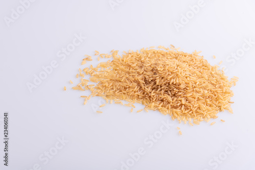 Raw Brown Rice on white background. Integral Wholegrain. Latin term Oryza sativa also known as Whole Chinese Rice seed