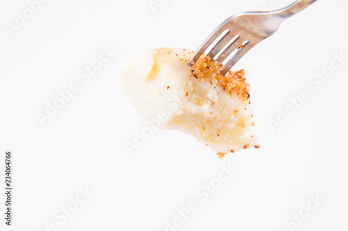 Dumplings with cottage cheese (traditional polish dish called lazy pierogi/ leniwe pierogi) fried with bread crumbs and sprinkled with sugar on a fork