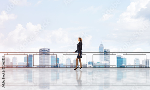Sunrise above skyscrapers and businesswoman facing new day