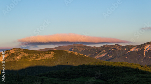 Strange cloud above mountain ridge and sunrise photo