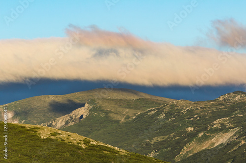 Strange cloud above mountain ridge and sunrise photo