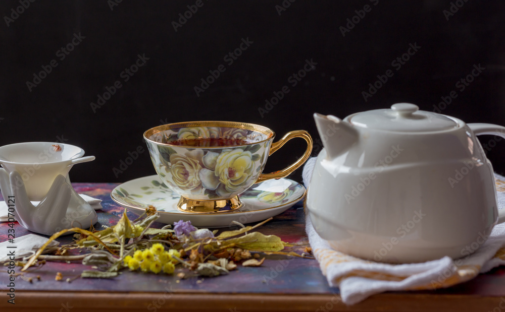 cup of tea, teapot and strainer on painted wooden table cup of tea, teapot and strainer on painted wooden table