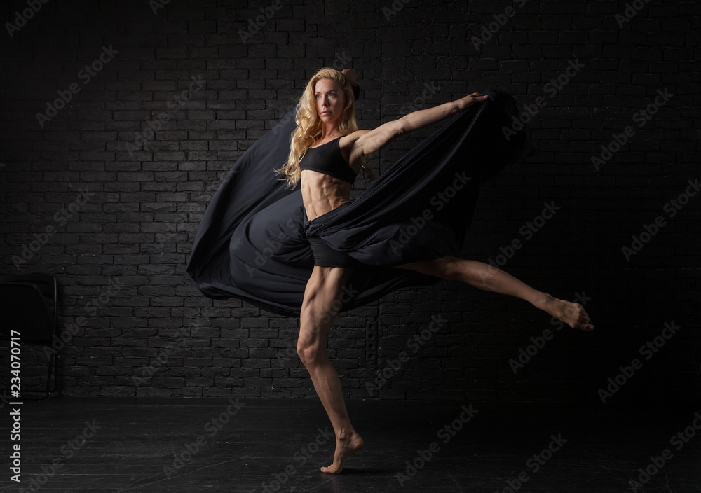 Young blonde ballerina in sportswear underwear dances and jumps in a studio  with black brick on the background. modern ballet performance. Perfect  fitness woman body Stock Photo | Adobe Stock
