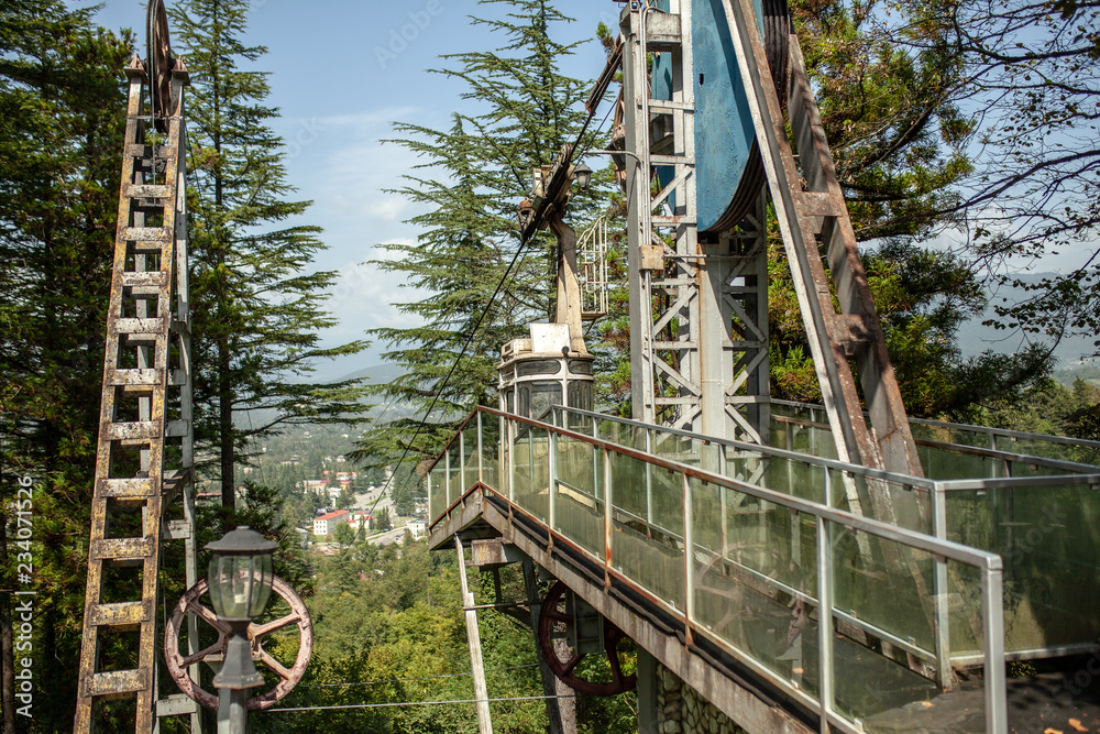 Station of the old cable car. Rust and ruin on the background of pine trees