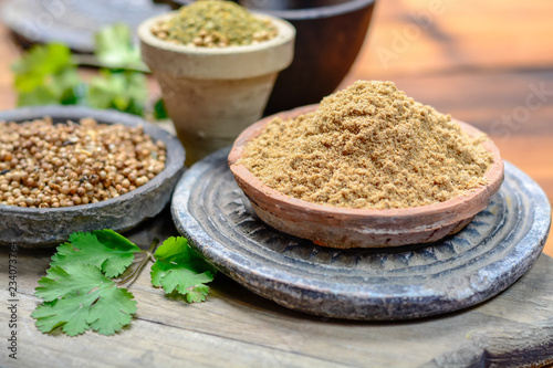 Clay bowls wirh dried coriander seeds and coriander powder close up, spices collection