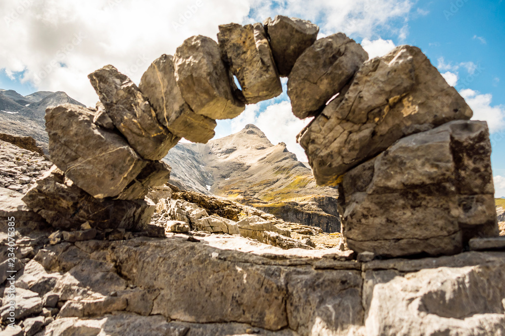 scenery with arch made of stone in the swiss mountains