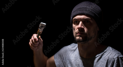 man paints a brush with white paint on a black background, industrial concept.