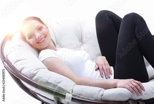 tired woman resting in an easy chair made of rattan