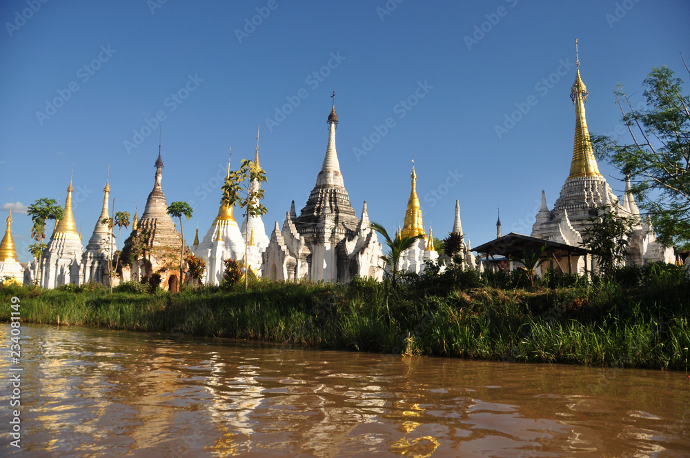 Ancient temple on shore of lake, Landscape of brown water of lake Inle with plenty of sacred temple stupas and payas on shore. Inle, Myanmar,Burma. Ancient temple on shore of lake, Landscape of brown water of lake Inle with plenty of sacred temple stupas and payas on shore. Inle, Myanmar,Burma.