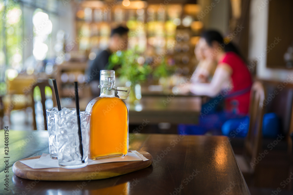 Glass bottle of ice tea on table in vintage style restaurant