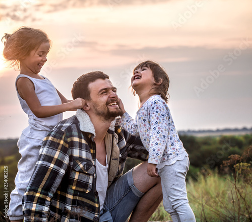 dad playing with two little cute daughters