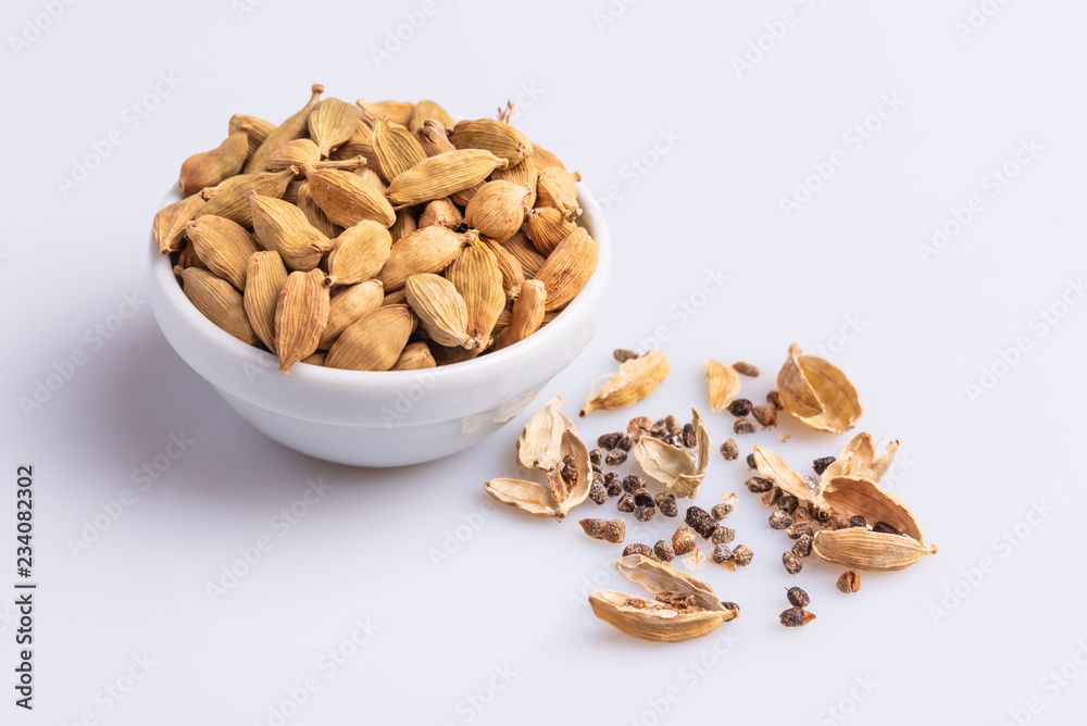 Dry Cardamom pod in a stone mortar, isolated on white background, latin term Elettaria cardamomum, with copy space, angle view, soft light. Dry Cardamom pod in a stone mortar, isolated on white background, latin term Elettaria cardamomum, with copy space, angle view, soft light.