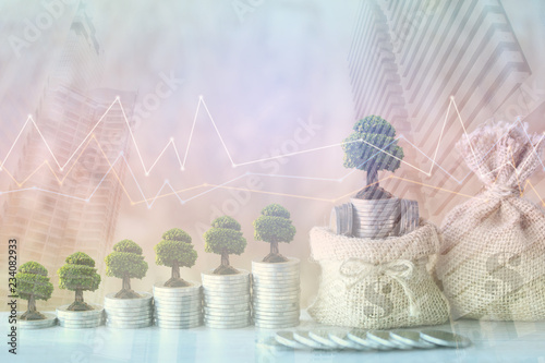 Double exposure of Trees growing on coins money with money bag and graph on city background, investment and business concept photo