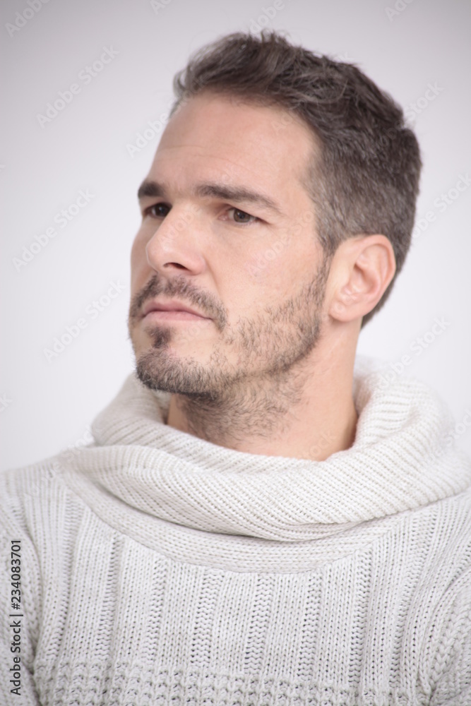 Obraz premium Man worries in a white sweater in front of a white background