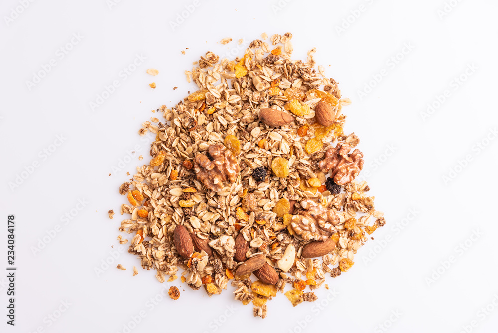 Granola or muesli with nuts and rasins on a white background, top view, copy space, soft light Granola or muesli with nuts and rasins on a white background, top view, copy space, soft light