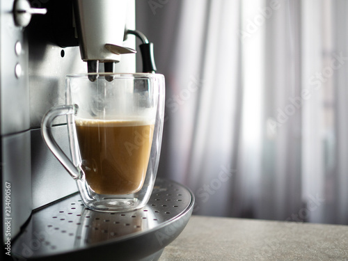 Process of making coffee by coffee machine pour coffee into the cup. Coffe latte. Morning