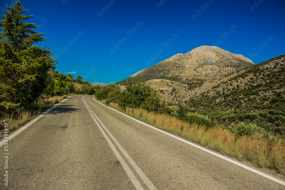Empty curved car road in highland nature environment landscape with mountain ridge background in clear weather time Empty curved car road in highland nature environment landscape with mountain ridge background in clear weather time