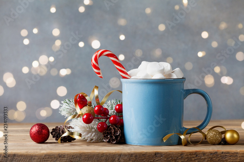 Winter lifestyle with cup of hot cocoa with marshmallows and Christmas decoration on wooden background. Bokeh effect.