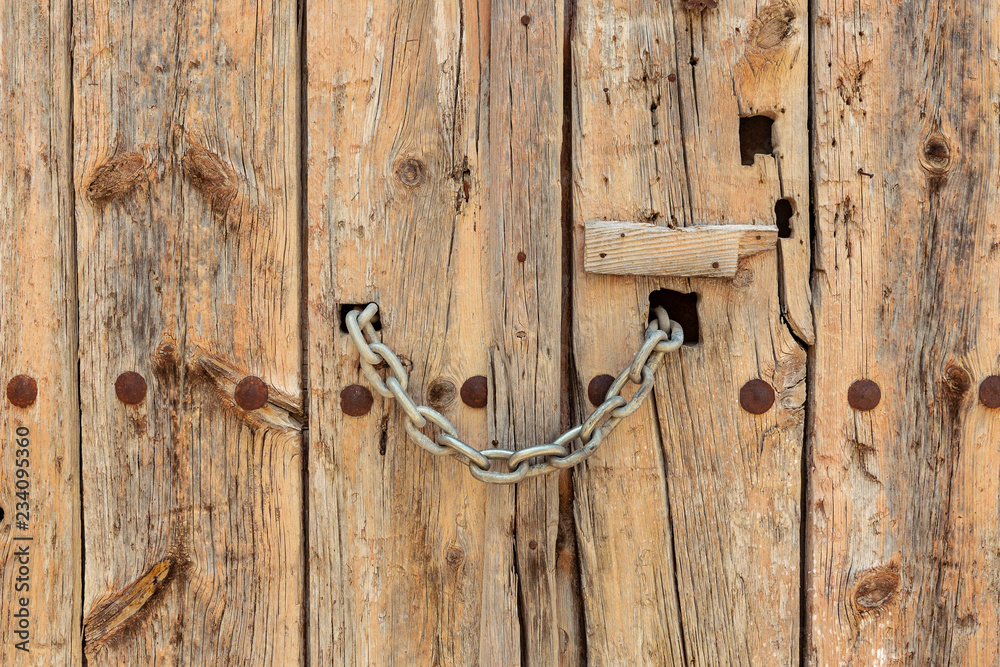 ancient old wooden door locked with a chain ancient old wooden door locked with a chain