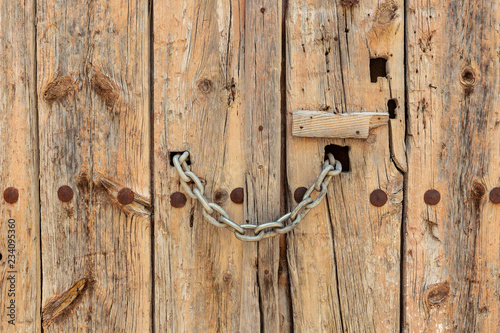 ancient old wooden door locked with a chain