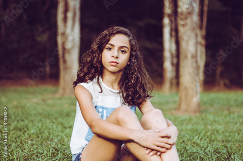 Beautiful smiling girl sitting on the park grass