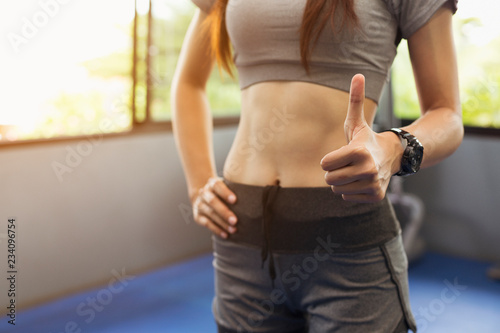 Female fitness is thumbs up to show appreciation.