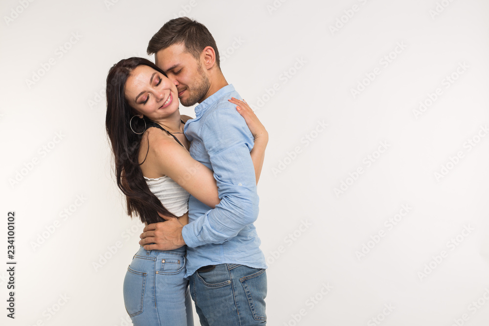 Handsome man hugging his girlfriend on white background with copy space