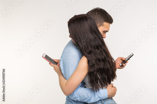 Slika na platnu Smartphone addiction concept - Young couple using internet on mobile phone, ignoring each other