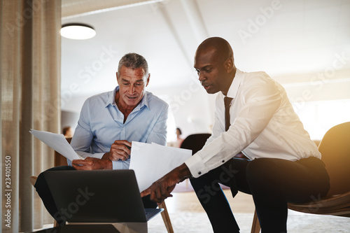 Obraz na plátne Two diverse businessmen discussing work together in an office