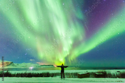 Colorful Aurora Borealis or better known as The Northern Lights and winter milky way over Kirkjufell, Iceland