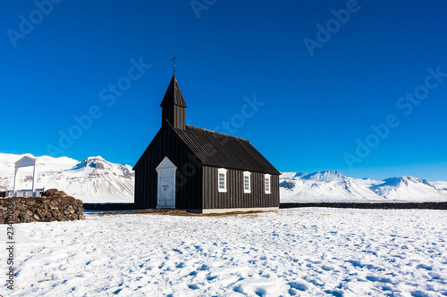 Budakirkja or better known as The Black Church view with blue sky during winter snow, Iceland
