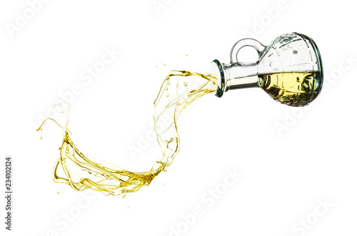 Olive oil pouring from glass bottle isolated against white background