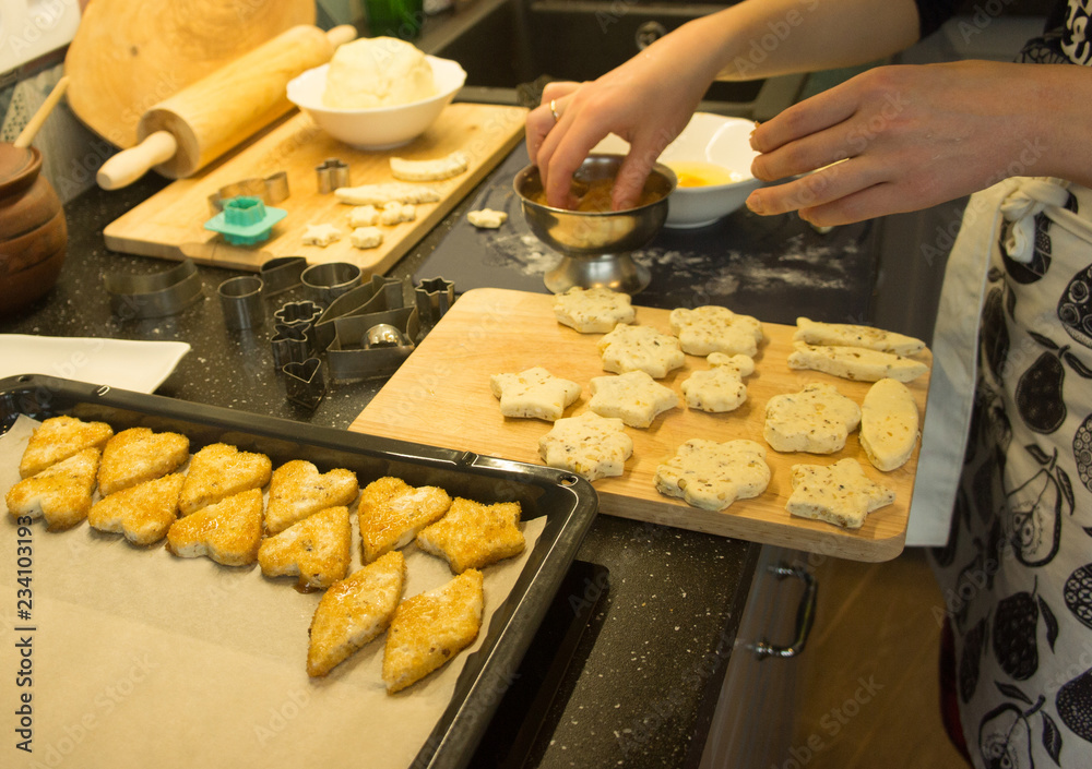 The process of baking cookies at home, close-up on the cookie cutter on the dough and rolling pin on a wooden Board