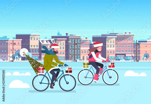 couple riding bike with fir tree gift box over city street buildings cityscape background merry christmas new year concept flat horizontal vector illustration