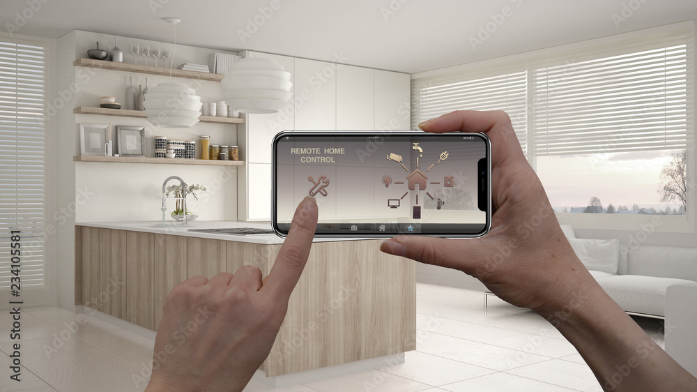 Remote home control system on a digital smart phone tablet. Device with app icons. Interior of modern kitchen with shelves and cabinets in the background, architecture design Remote home control system on a digital smart phone tablet. Device with app icons. Interior of modern kitchen with shelves and cabinets in the background, architecture design