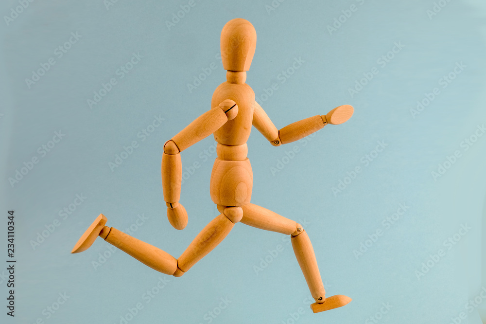 Wooden dummy running on light blue background Wooden dummy running on light blue background