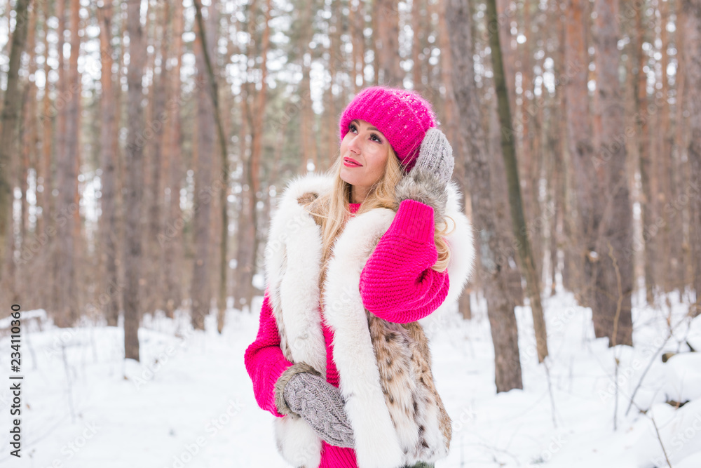 Nature, fashion and winter concept - Pretty young woman in pink warm jacket in snowy park Nature, fashion and winter concept - Pretty young woman in pink warm jacket in snowy park
