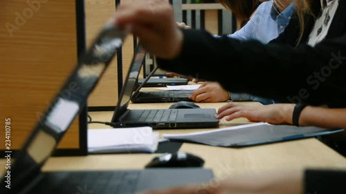 Many hands are typing on a laptop