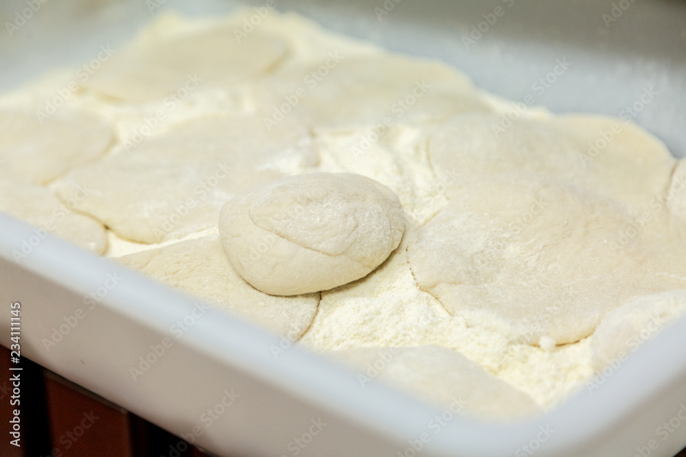 Close up of a tray in a restaurant kitchen with raw mass and flour Close up of a tray in a restaurant kitchen with raw mass and flour