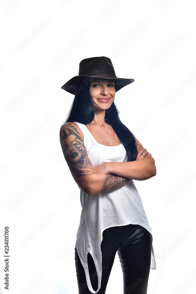Dark long haired girl wearing a cowboy hat and a sleeveless white shirt posing isolated on white. Dark long haired girl wearing a cowboy hat and a sleeveless white shirt posing isolated on white.