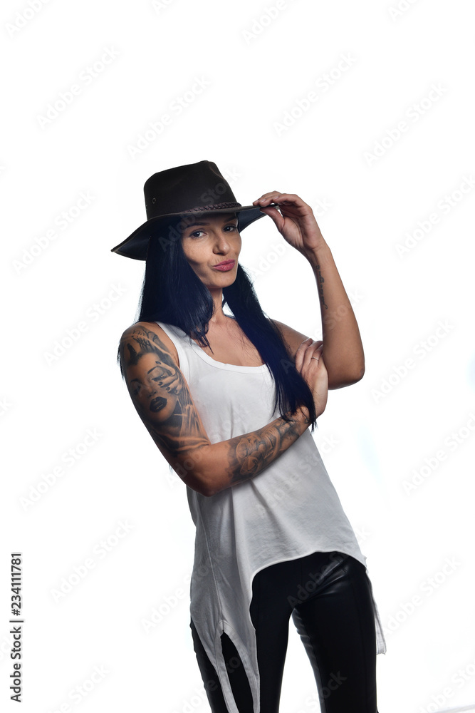 Dark long haired girl wearing a cowboy hat and a sleeveless white shirt posing isolated on white. Dark long haired girl wearing a cowboy hat and a sleeveless white shirt posing isolated on white.
