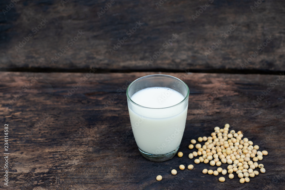 Soy milk and soy bean on wooden table and dark rustic kitchen background. Alternative milk concept. selective focus Soy milk and soy bean on wooden table and dark rustic kitchen background. Alternative milk concept. selective focus