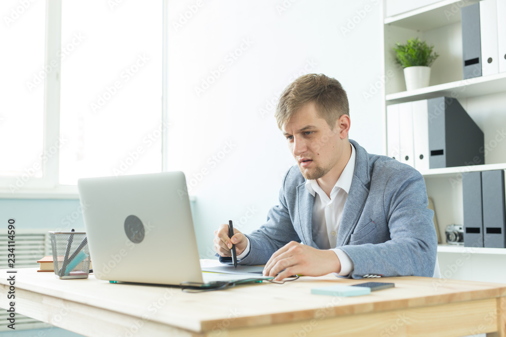 Designer, artist and web design concept - Portrait of young man using digital pen tablet and laptop in the office Designer, artist and web design concept - Portrait of young man using digital pen tablet and laptop in the office