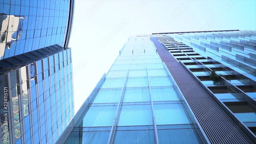Spinning footage, Look up point of view, Low angle shot of tall high rise building with blue sky