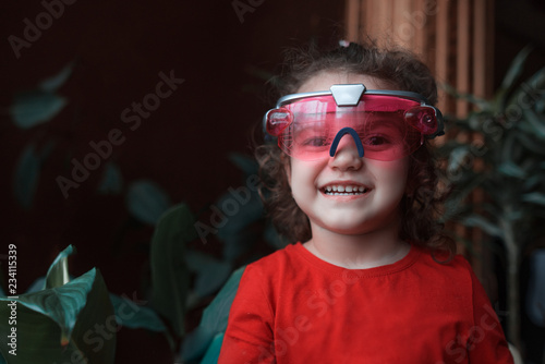 Portrait of smiling kid girl playing home with VR headset toy