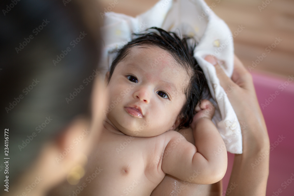 Asian new born having a bath by mother Asian new born having a bath by mother
