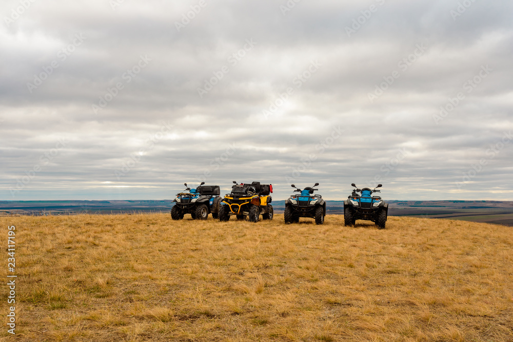 Fototapeta premium ATVs in the field in the highlands, on cloudy day