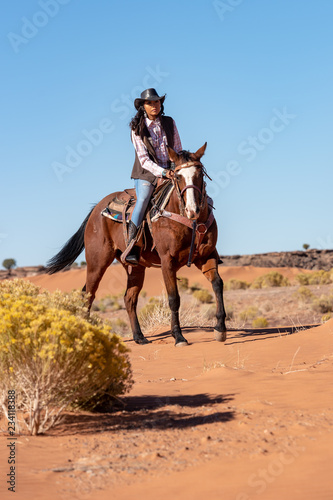 native american woman riding horse in desert