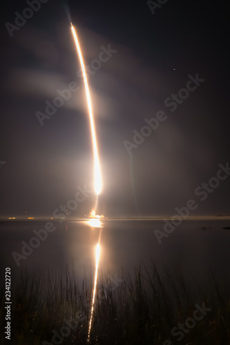 fire trail of a rocket taking off in a hazy night sky