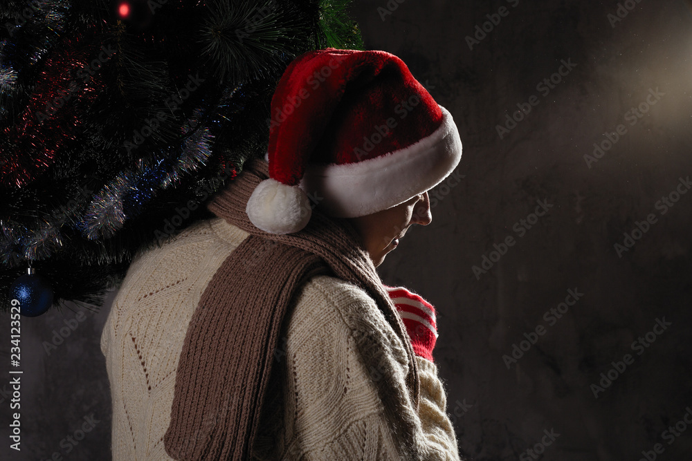 Christmas gift concept. Man in santa hat bring gift for you. Attractive man hold box. Christmas and new year holiday celebration. Man hold christmas tree and take it home, wear hat, scarf, sweater Christmas gift concept. Man in santa hat bring gift for you. Attractive man hold box. Christmas and new year holiday celebration. Man hold christmas tree and take it home, wear hat, scarf, sweater